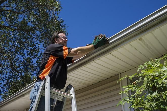 worker fixing a broken gutter on a house in Allison IA